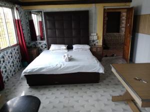 a bedroom with a bed with two teddy bears on it at countryside view hotel Silchar in Silchar