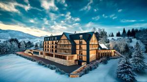 an image of a house in the snow at Hotel Panorama Kope in Šmartno pri Slovenj Gradcu
