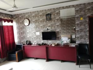 a room with a desk and a tv on a wall at countryside view hotel Silchar in Silchar