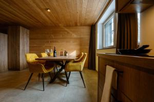 a small dining room with a table and yellow chairs at Hotel Panorama Kope in Šmartno pri Slovenj Gradcu