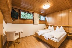 a bedroom in a boat with a bed and a desk at Apartments Chalet Zirm in Santa Cristina Gherdëina