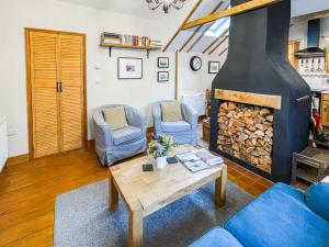 a living room with a fireplace and a table and chairs at Corner Cottage in Saxmundham