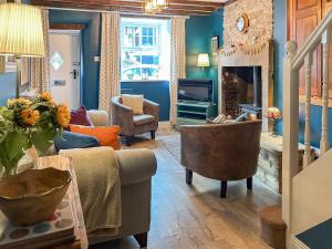 a living room with a couch and a fireplace at Parsley Cottage in Tideswell