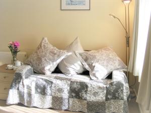 a pile of pillows sitting on top of a bed at Chynoweth in Saint Merryn