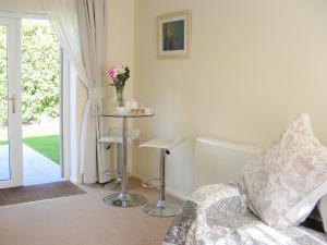 a living room with a couch and a table with flowers at Chynoweth in Saint Merryn