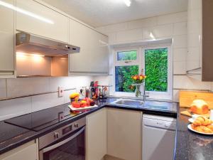 a kitchen with white cabinets and a sink and a window at Chynoweth in Saint Merryn +16 photos