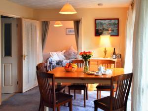 a dining room with a table and a bedroom at Chynoweth in Saint Merryn