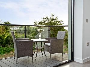 a patio with a table and chairs on a balcony at Black Sea Horse in Westward Ho