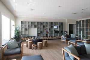 ein Wohnzimmer mit Sofas und einem Fernseher in der Unterkunft Hotel Fårup in Blokhus