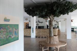 ein Tisch mit einem Baum in der Mitte eines Raumes in der Unterkunft Hotel Fårup in Blokhus