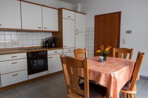 a kitchen with a wooden table and a table and chairs at Ferienwohnung Riesling in Klüsserath