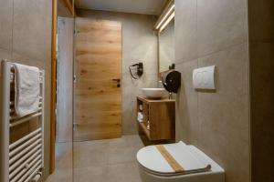 a bathroom with a toilet and a sink at Hotel Panorama Kope in Šmartno pri Slovenj Gradcu +32 photos
