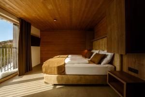 a bedroom with a bed and a balcony at Hotel Panorama Kope in Šmartno pri Slovenj Gradcu
