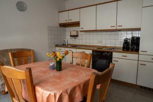 a kitchen with a table with a vase of flowers on it at Ferienwohnung Riesling in Klüsserath +6 photos