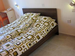 a bed with a brown and white comforter and pillows at Corner Hostel in Sliema