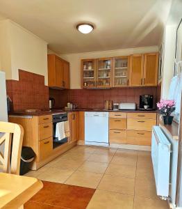 a kitchen with wooden cabinets and white appliances at Leśny Poranek in Iwkowa