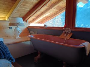 a bath tub in a room with a window at B&B Baita Bertolini in Monclassico