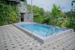 a small swimming pool in a yard with a fence at Chamee Oasis Villa in Ranna