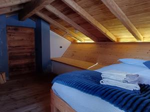 a bed in a room with a wooden ceiling at B&B Baita Bertolini in Monclassico +49 photos