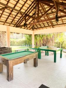 three ping pong tables sitting under a roof at Vg Sun Cumbuco 112 in Caucaia