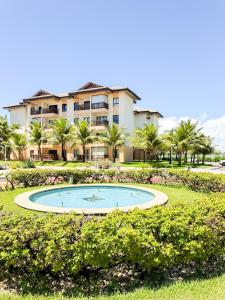 a building with a pool in front of a resort at Vg Sun Cumbuco 112 in Caucaia