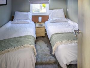 two beds in a small room with a window at Solo's in East Heslerton +10 photos