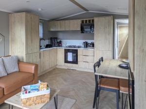 a kitchen and living room with a couch and a table at Solo's in East Heslerton
