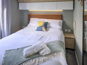 a bedroom with a bed with towels on it at Solo's in East Heslerton