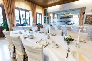a dining room with white tables and white chairs at Hotel Restaurant Zur Eisernen Hand in Viersen