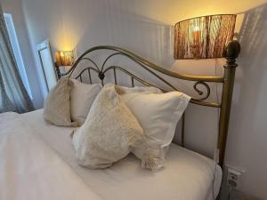 a bed with white pillows and a lamp on it at Cazare Vidin in Basarabi