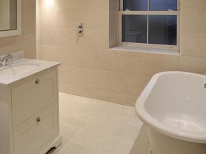 a bathroom with a sink and a toilet and a window at Midge in Newlyn