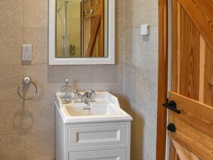 a bathroom with a white sink and a mirror at Midge in Newlyn