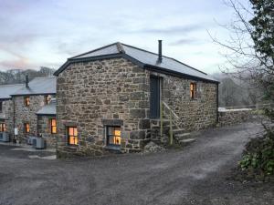 a stone house with orange lights in the windows at Midge in Newlyn
