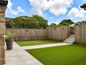 a garden with a wooden fence and green grass at Midge in Newlyn +28 photos