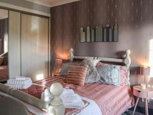 a bedroom with a large bed with pillows on it at Dothan Farm Cottage in Cardenden