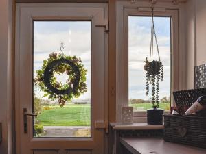 a kitchen door with a wreath on the window at Dothan Farm Cottage in Cardenden