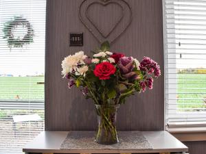 a vase filled with flowers sitting on a table at Dothan Farm Cottage in Cardenden