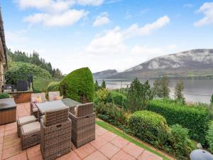 an outdoor patio with chairs and a view of a lake at Lochside View in Lochearnhead