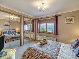 a bedroom with two beds with a teddy bear on the bed at Lochside View in Lochearnhead