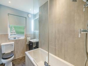 a bathroom with a tub and a toilet and a sink at Lochside View in Lochearnhead +19 photos