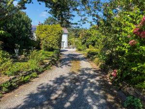 a garden path with a house in the background at Rosehill in Truro