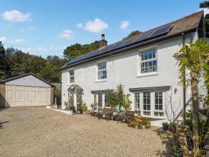 a white house with a driveway and a garage at Rosehill in Truro