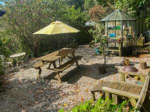 a picnic table and an umbrella in a garden at Rosehill in Truro