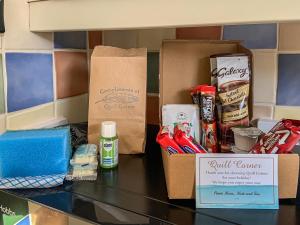 a counter topped with boxes of food and other items at Quill Corner in Alnwick