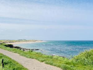 a dirt road next to a body of water at Quill Corner in Alnwick +25 photos