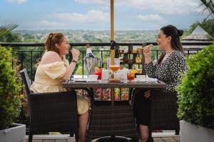 two women sitting at a table eating food at DoubleTree by Hilton Bristol South - Cadbury House in Yatton