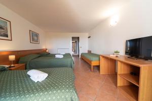 ein Hotelzimmer mit zwei Betten und einem Flachbildfernseher in der Unterkunft Hotel Marina 2 in Marina di Campo