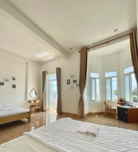 a bedroom with a bed and a desk and windows at Thu Quy Hotel in Cu Lao Thu +23 photos