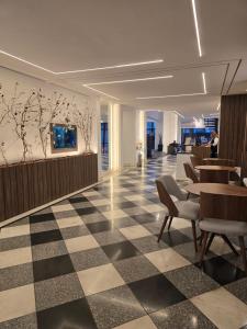 a lobby with a checkered floor and tables and chairs at Plaza Inn Small Town Flat in São Paulo