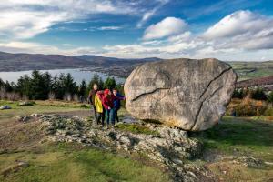 a group of people standing next to a large rock at Rostrevor Beach House in Rostrevor +3 photos